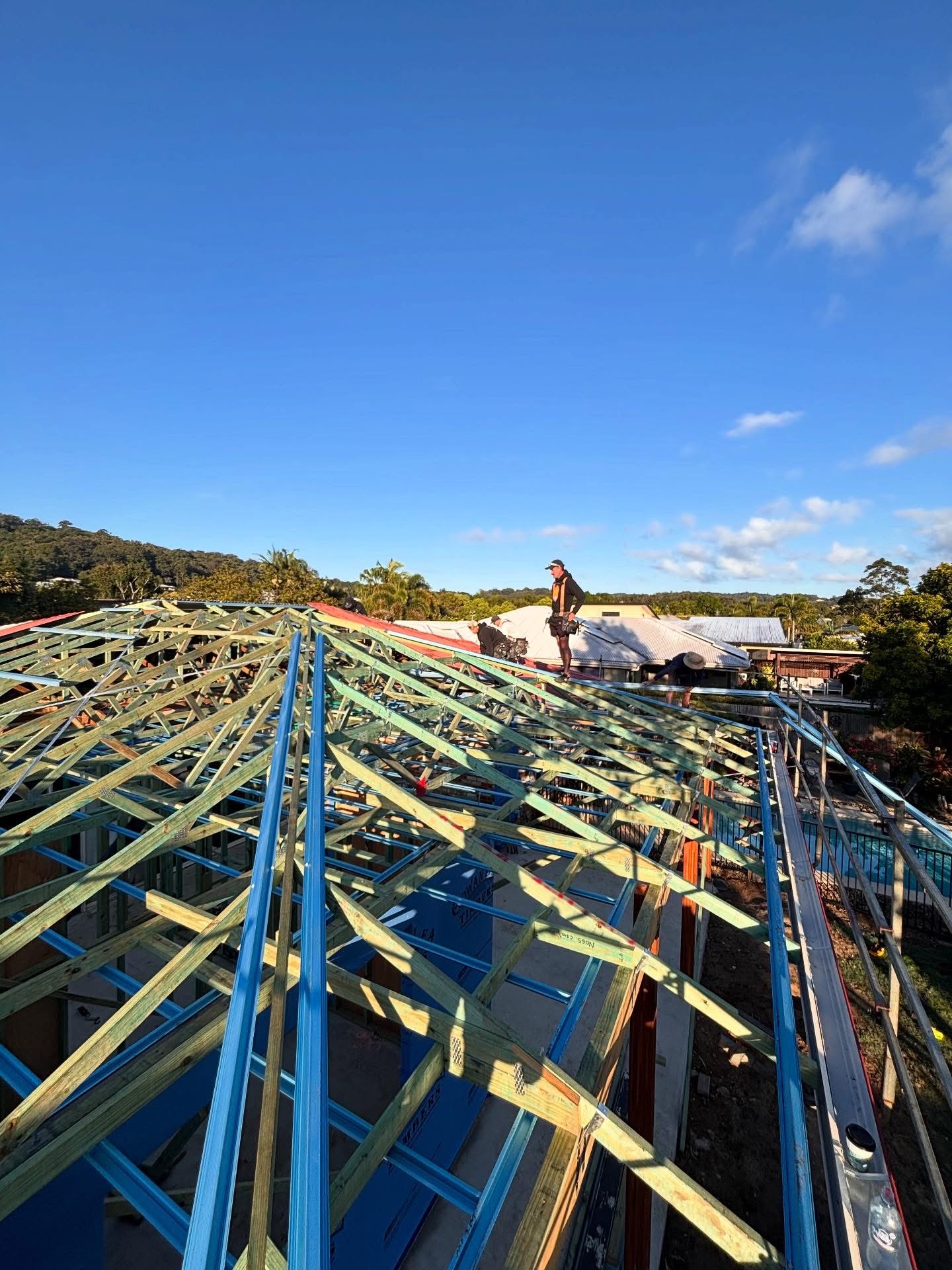 Roofers working on steel roof trusses for a new build on the Sunshine Coast