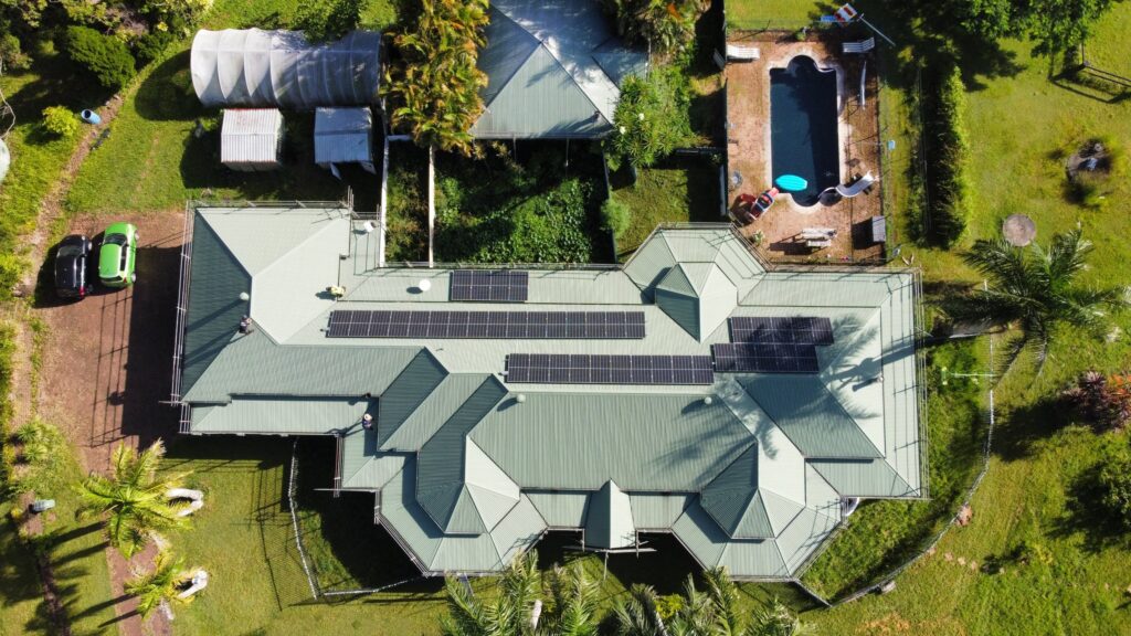 Aerial view of a green metal roof with solar panels on the Sunshine Coast