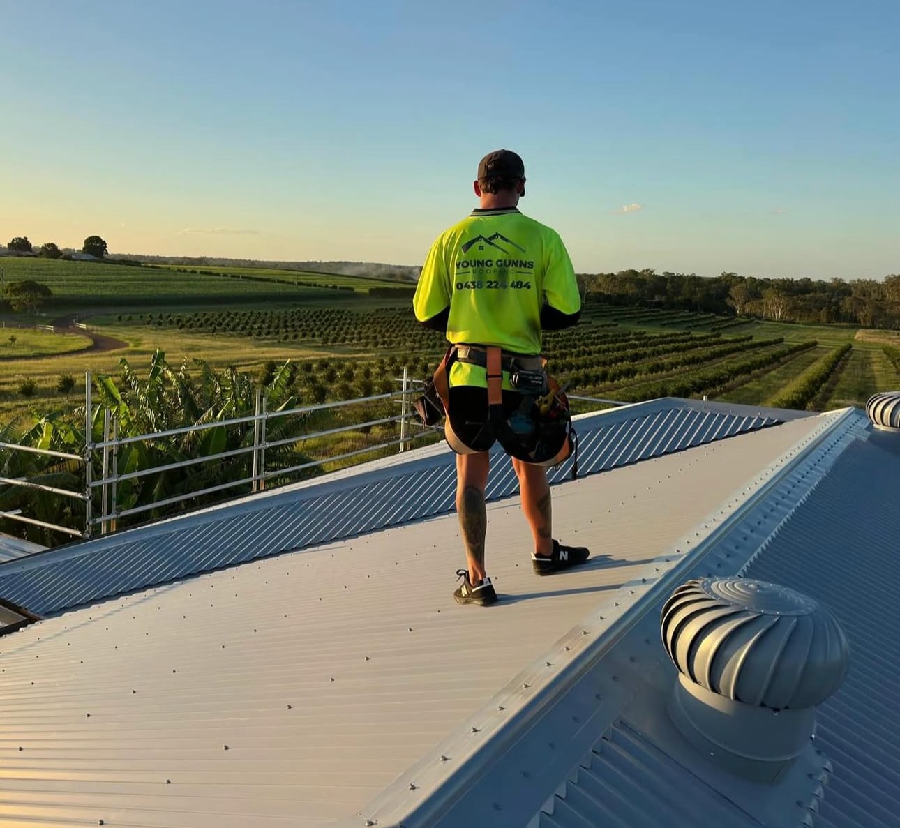 Young Gunns Roofing roofer walking across a new metal roof on the Sunshine Coast