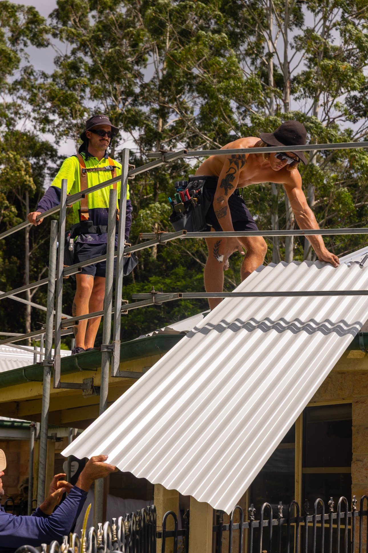 Young Gunns Roofing crew installing new metal roof sheets
