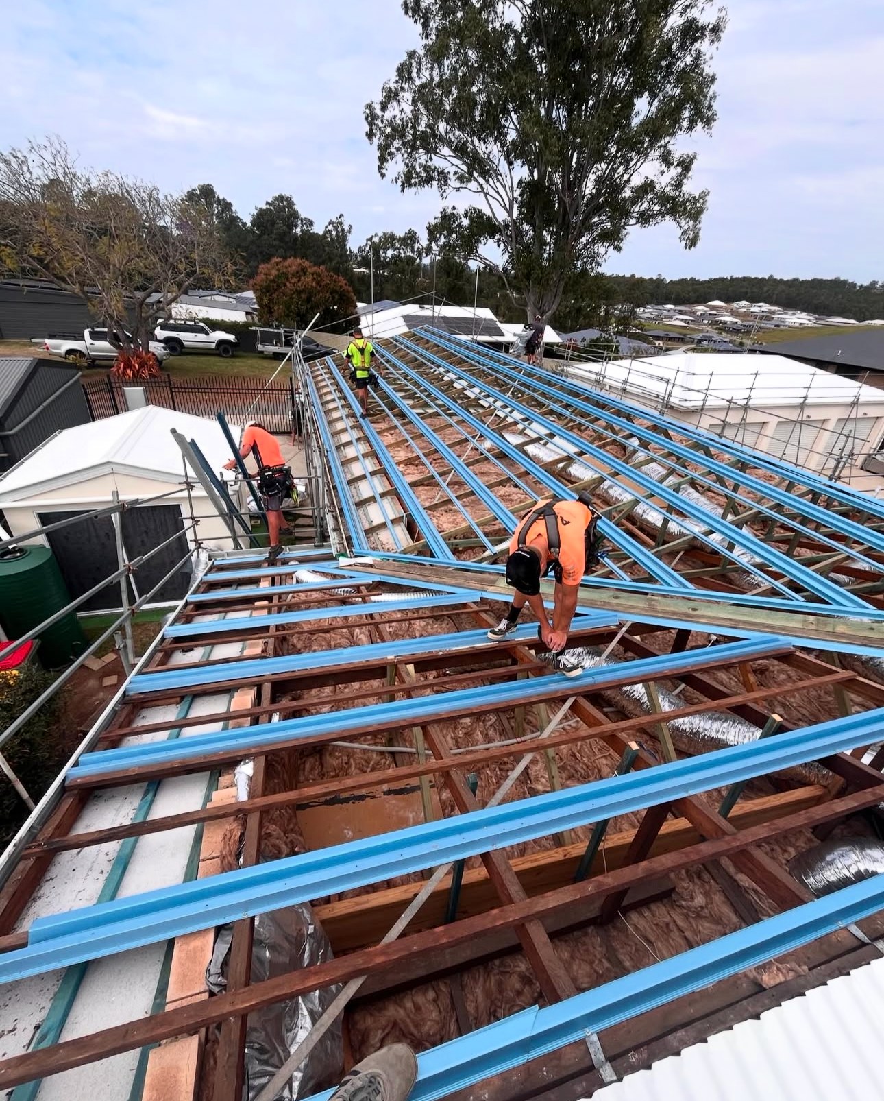 Roofers working on steel roof trusses for a new build on the Sunshine Coast